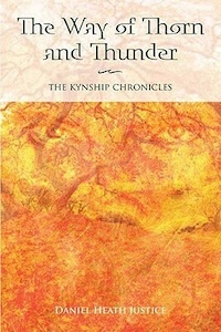 The book cover is fulled with orange and red and yellow flames covering the vague image of ground and a tree with one or two faces in the center of the image - two eyes are visible but it looks like there might be two faces half on top of each other in the middle of it. The title of the book is on the top with a white transparent background over the tree  and the authors name is at the bottom.