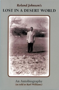 The cover of Lost in a Desert World is taken up by a black and white photograph of Roland wearing a suite standing on the grounds of Pennhurst.  The picture is framed with pale brown on the top and bottom where the title and author information are written